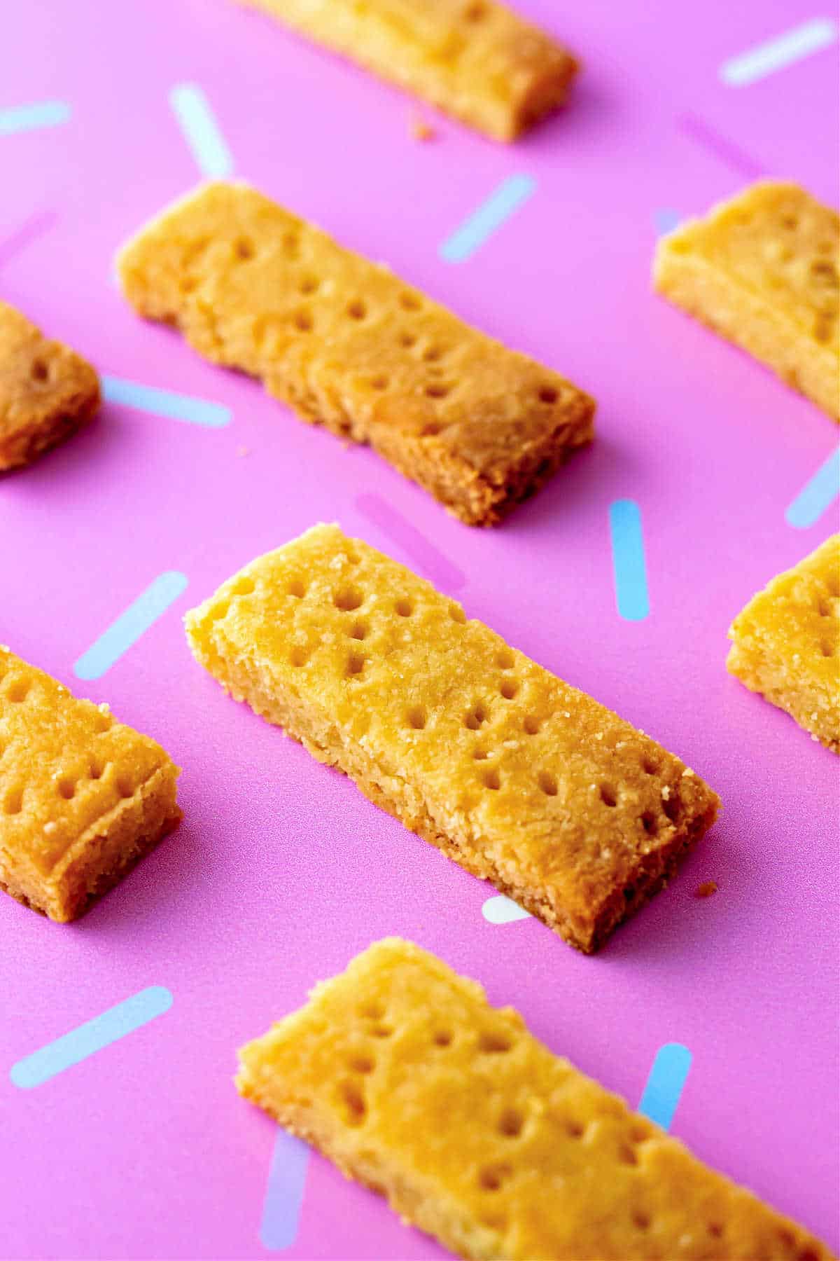 Rows of bars of shortbread on a pink background.