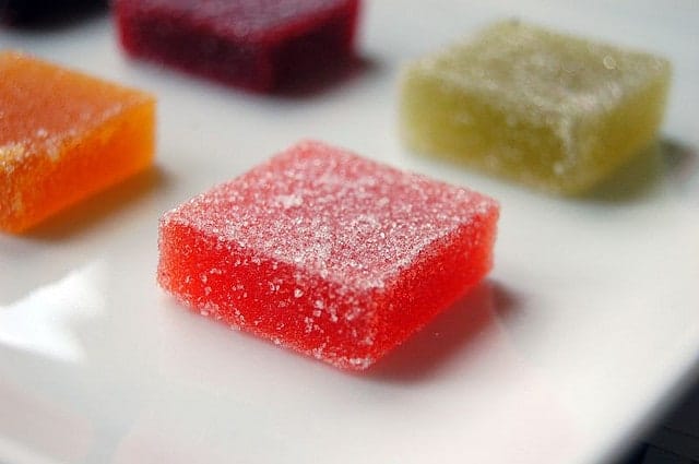Different colored squares of pate de fruits on a white plate.