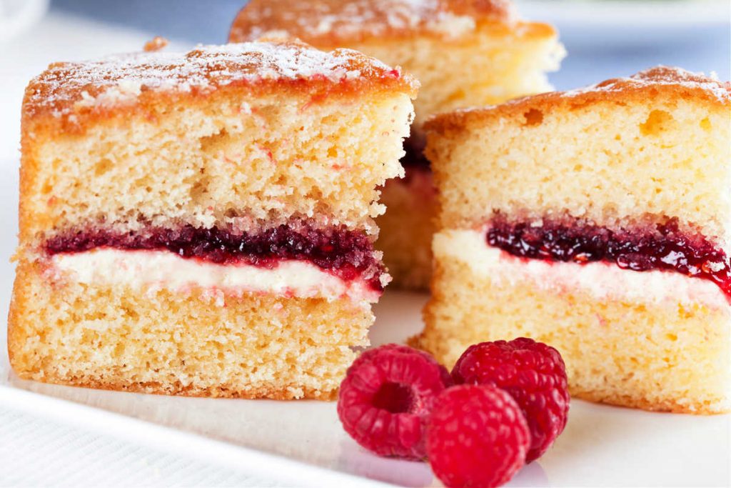 Slices of Victoria sponge: layers of spongecake sandwiching raspberry jam and whipped cream.