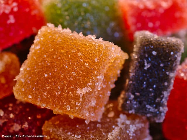 Close up of different colored squares of fruit candy or pate de fruits with sugar coating.