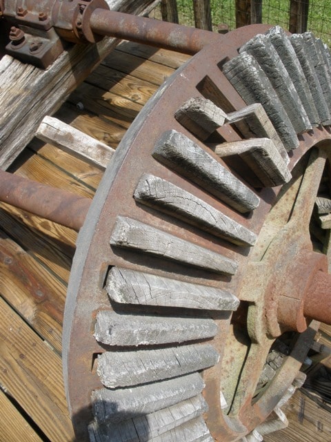 close up of the old gears that powered the mill. The wheel is iron and the teeth are made of wood.