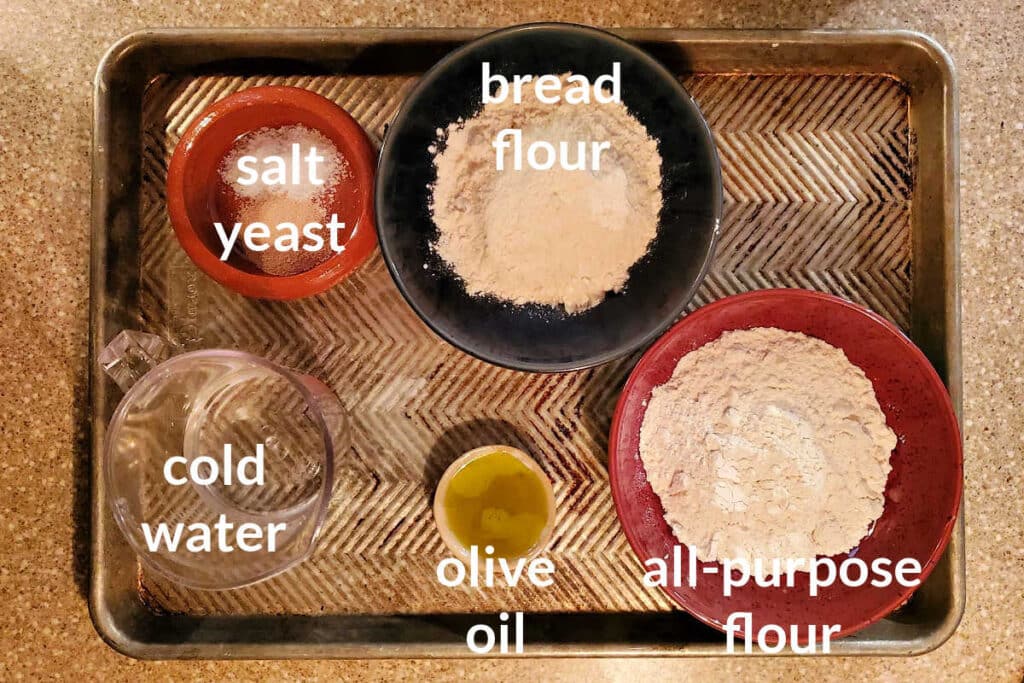 A collage of ingredients for making easy pizza dough shot overhead on a sheet tray.