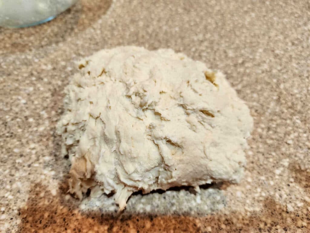 A shaggy, messy ball of dough on a countertop.