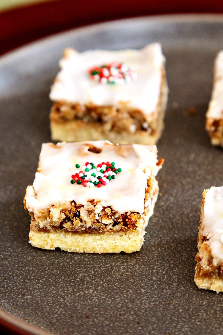 Angel pecan squares with Christmas sprinkles on top, served on a neutral color plate.
