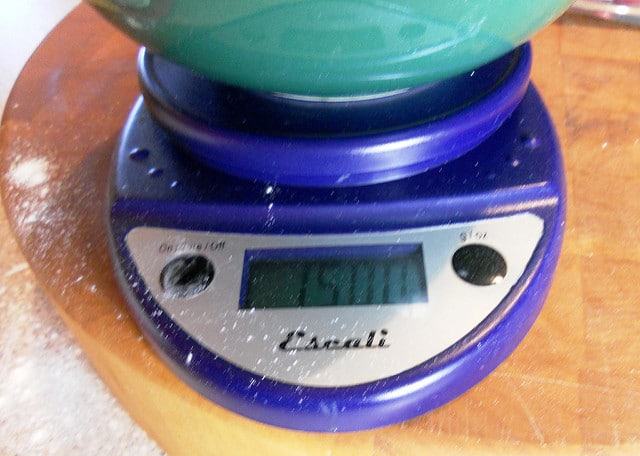 A digital scale with a bowl on it showing 15 oz.