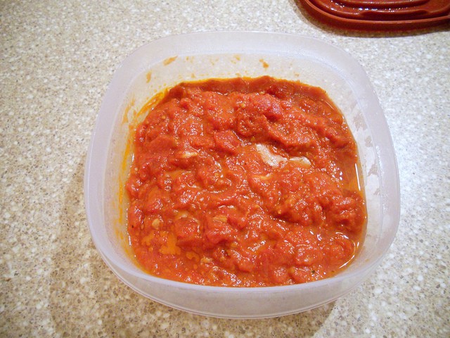 A plastic food storage bowl of leftover pasta sauce.