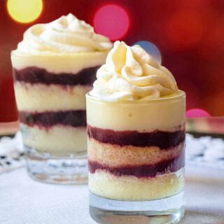 Two English trifles in glass dishes on a platter.