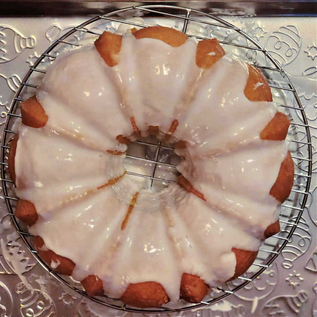 An overhead shot of a Bundt cake with fresh glaze poured over it.