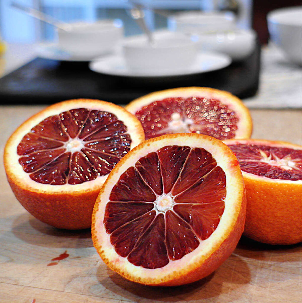 2 Moro blood oranges sliced in half showing deep red/orange flesh.