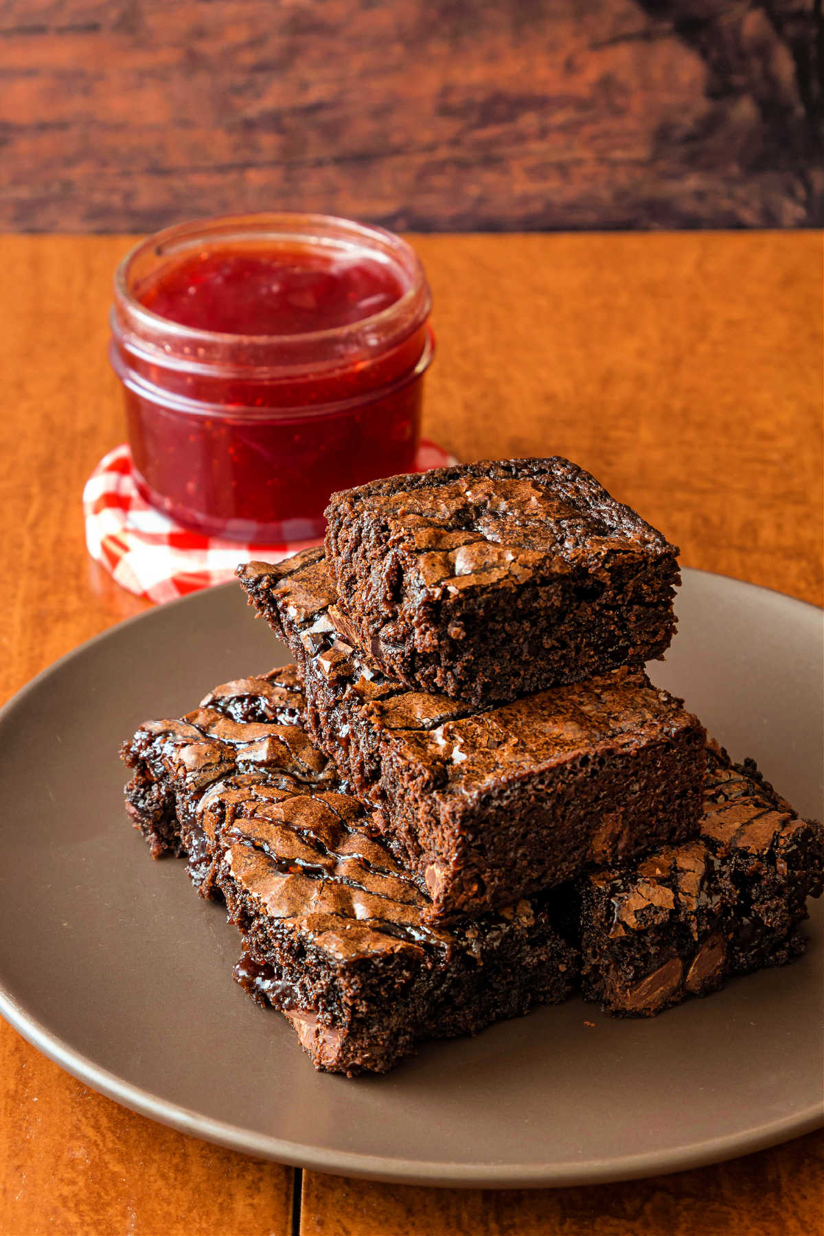A plate of strawberry swrirl brownies on a brown plate.