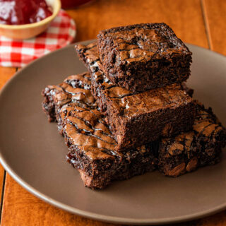 A sqare image of balsamic-infused strawberry swirl brownies on a plate.