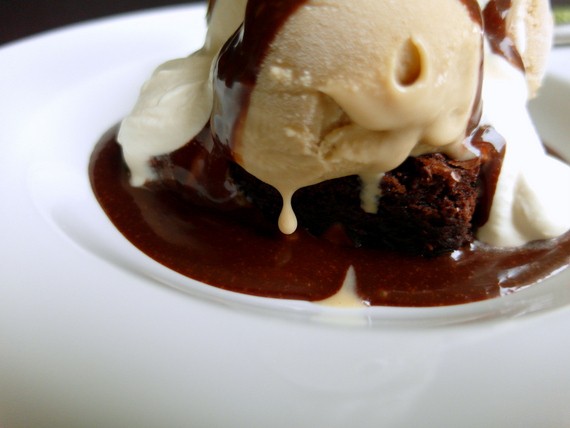 Side view Brownie Malt Sundae showing beige beer ice cream, the brownie, chocolate sauce and whipping cream.
