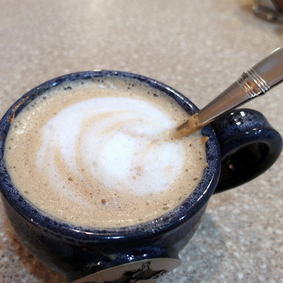 Finished beaten coffee Indian cappuccino in a blue earthenware mug.