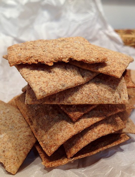 A stack of rye crackers on parchment paper.