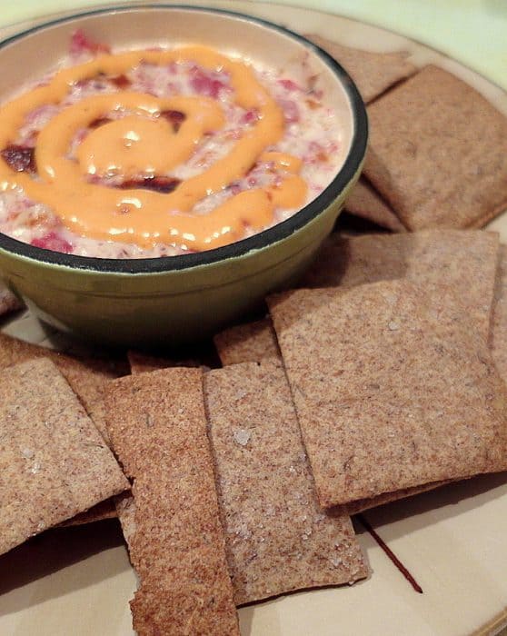 Rye crackers with caraway seeds and a dish of Rueben dip.
