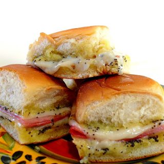 pile of ham and cheese sliders on a plate