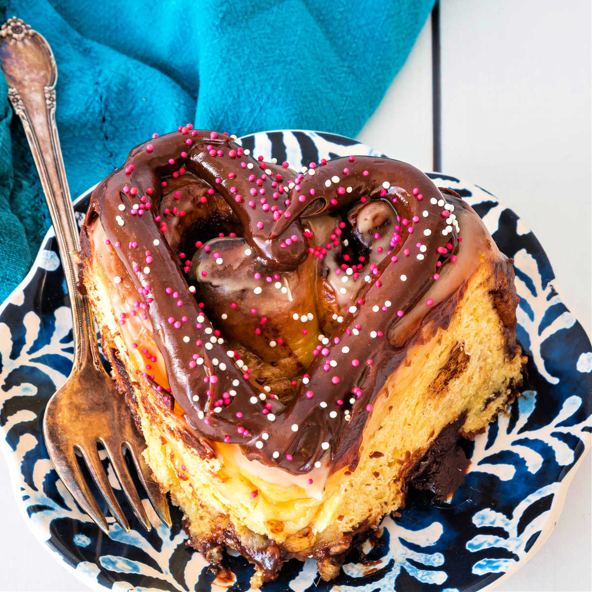 A heart-shaped chocolate honey bun with a fork.