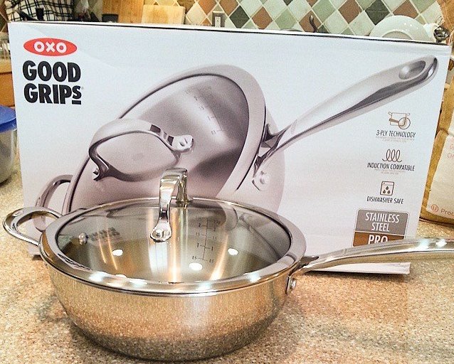 OXO good grips stainless steel saucepan with glass lid sitting next to box it came in.