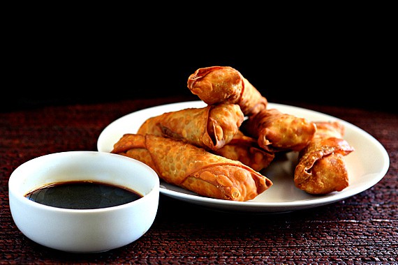 Fried pork appetizers with dipping sauce on a plate.