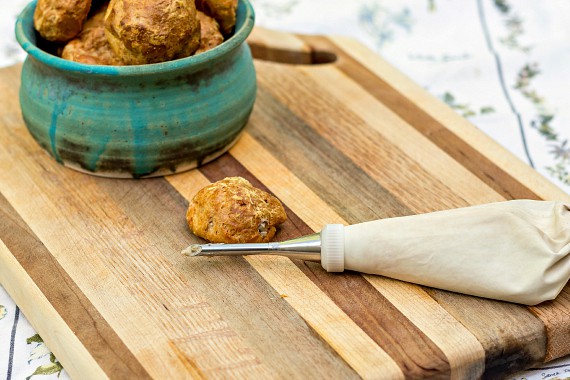 gougeres with bechamel aux champignons in a piping bag with a Bismarck tip