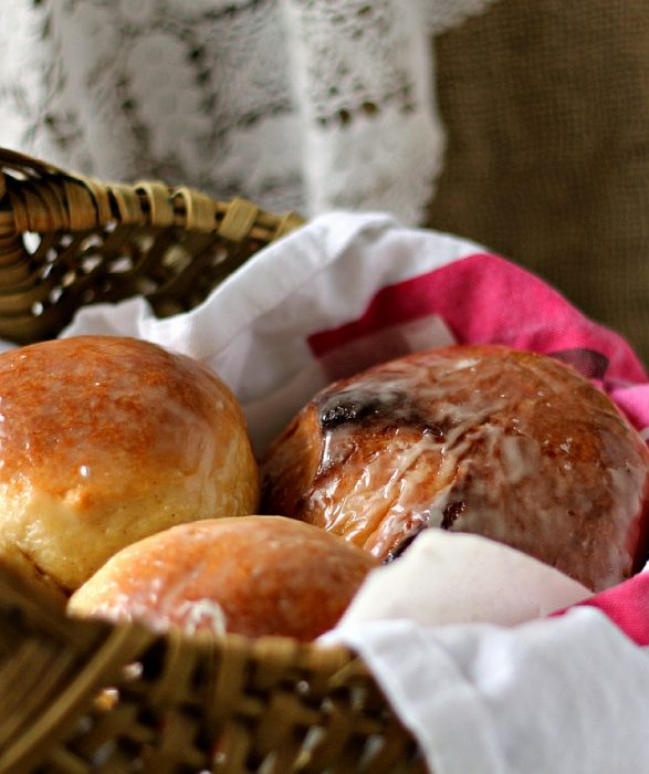 Round, glazed buns in a basket.