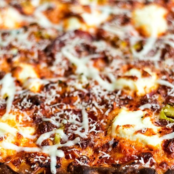 Close up view of a baked pizza with cheese and vodka sauce.