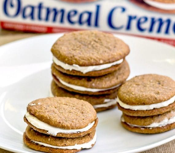 Stacks of sandwich cookies on a white plate.