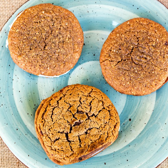 Overhead shot of three oatmeal cream pies on a blue plate.