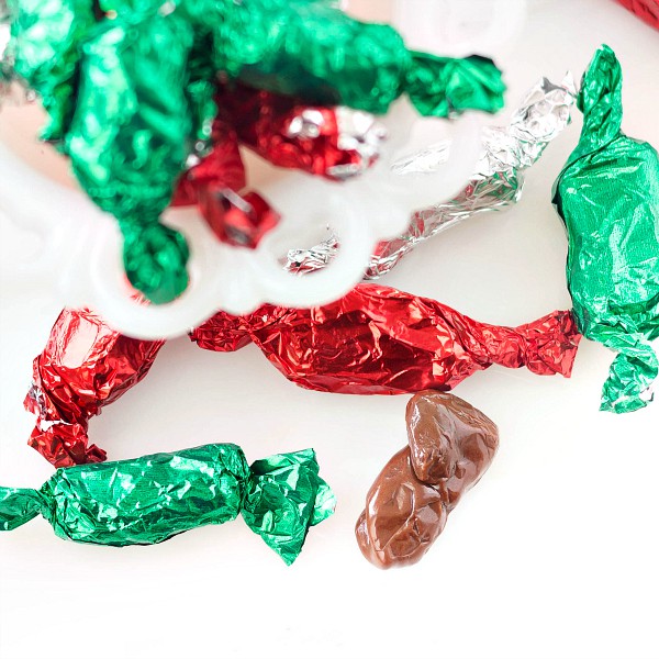 Homemade tootsie rolls wrapped in red, green, and silver foil.
