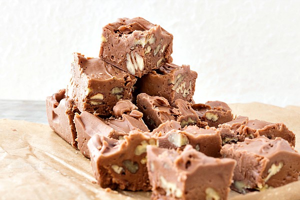 Squares of old fashioned creamy cocoa fudge with nuts.