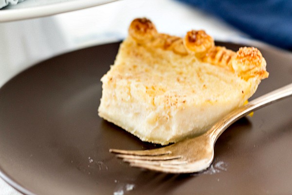 Half eaten piece of pie on a brown plate with a silver fork.