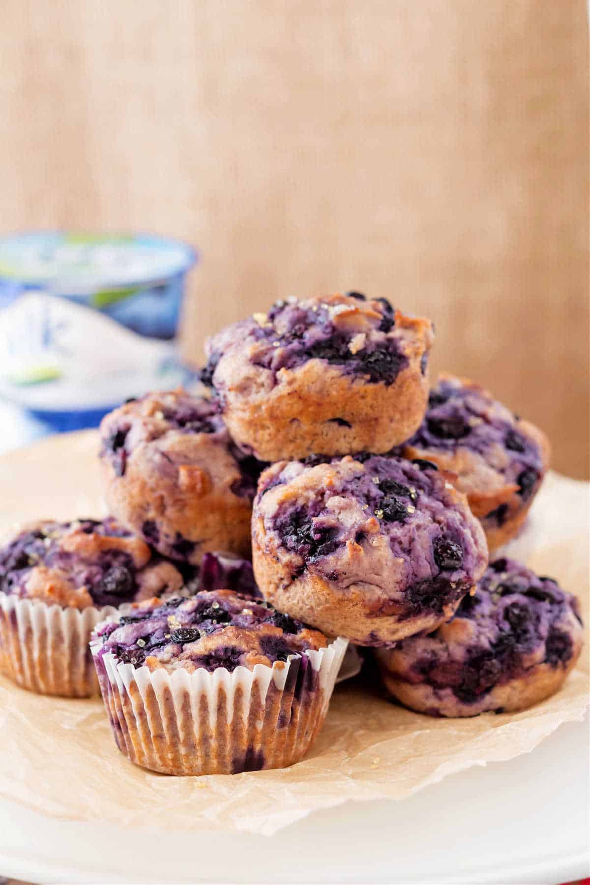 Pile of dairy free blueberry muffins on a white plate.