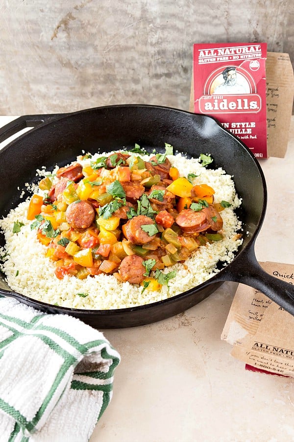 A skillet filled with cauliflower rice and Cajun sausage with peppers.
