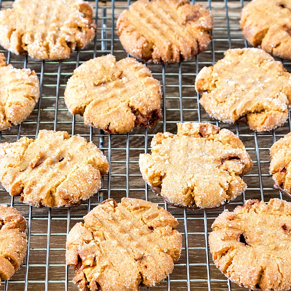 Overhead view of sugar-coated peanut butter cookies with familiar cross hatch design, on a cooling rack.