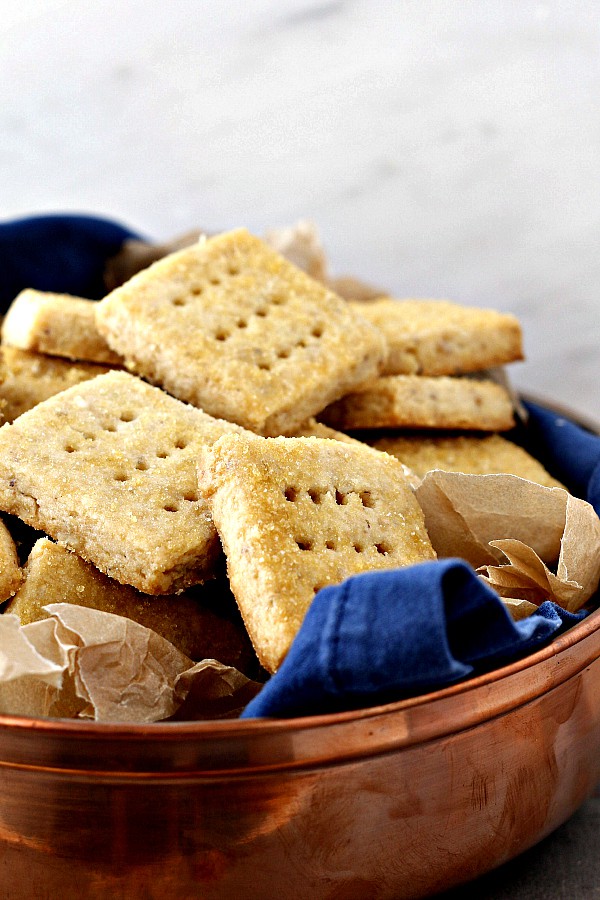 A container of square shortbread cookies with little holes pricked in them.