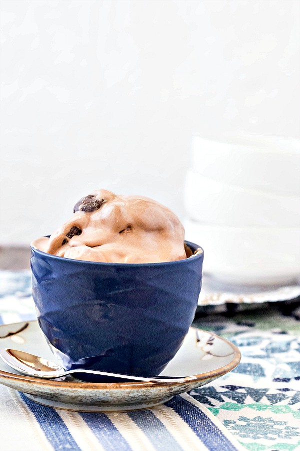 A blue bowl of Junior Mint Chocolate Ice Cream with a silver spoon.