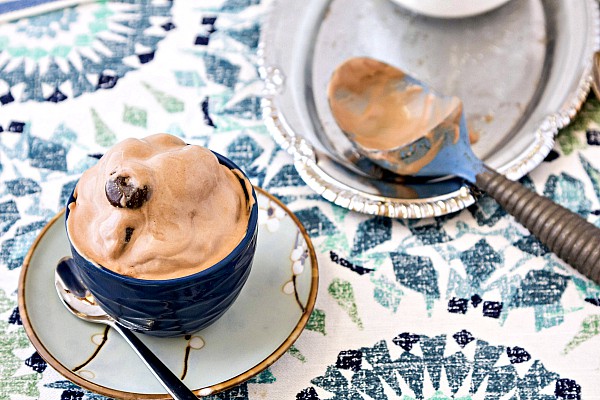 Junior Mint Chocolate Ice Cream in a bowl next to a used ice cream scoop, ready for serving.