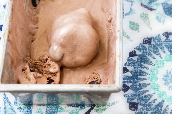 A metal loaf pan of Junior Mint Chocolate Ice Cream semi-melted.