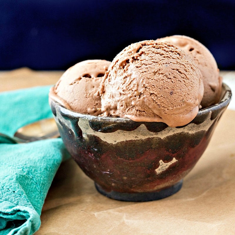 A bowl of 3 scoops of chocolate caramel ice cream.