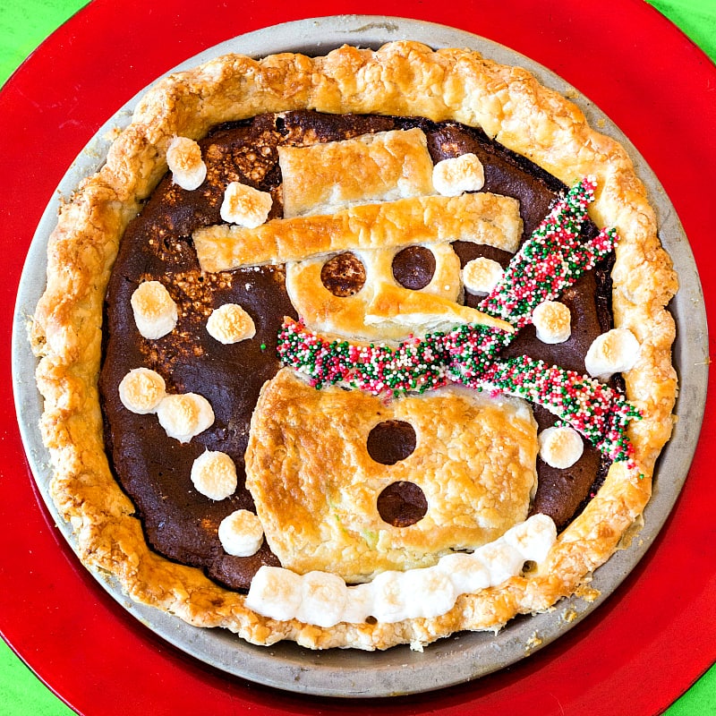  A whole hot chocolate pie with a snowman pie crust decoration, including sprinkles on the snowman's scarf and mini marshmallows for "snow".