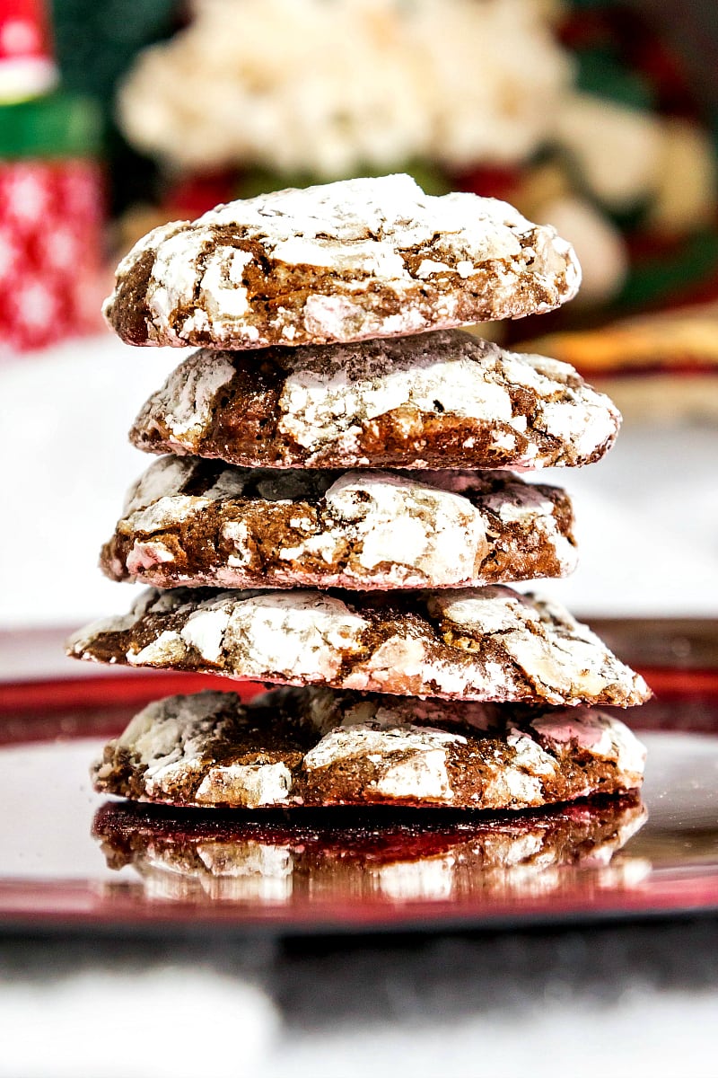 A stack of chocolate crinkle cookies on a red plate.