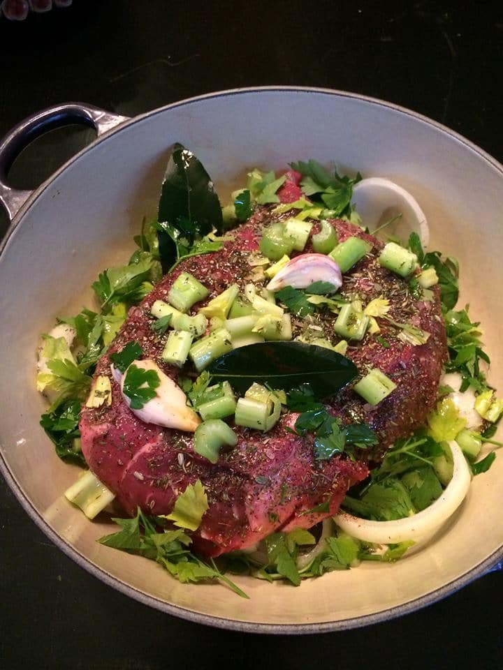 The Best Grass-Fed Pot Roast from Heidi Billotto Cooks in a Dutch oven with celery, onion, parsley and bay leaf, all ready for the oven.