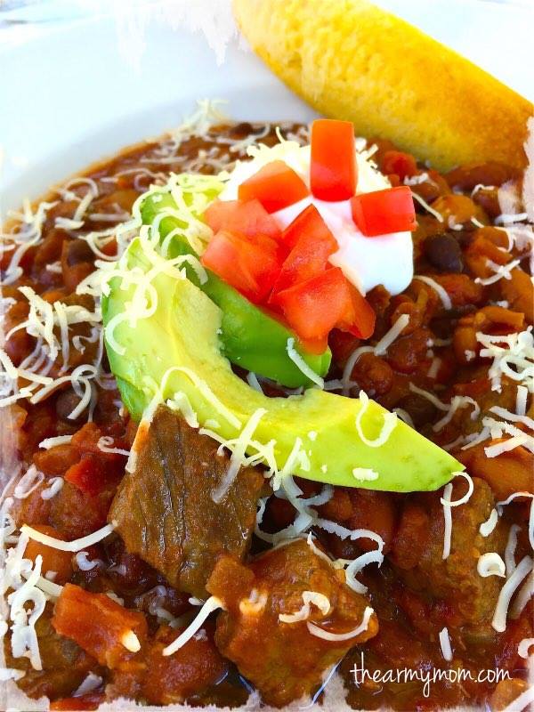 Close up of Got To Be NC Beef Hearty Chili by The Army Mom, garnished with avocado, diced tomato, and sour cream.
