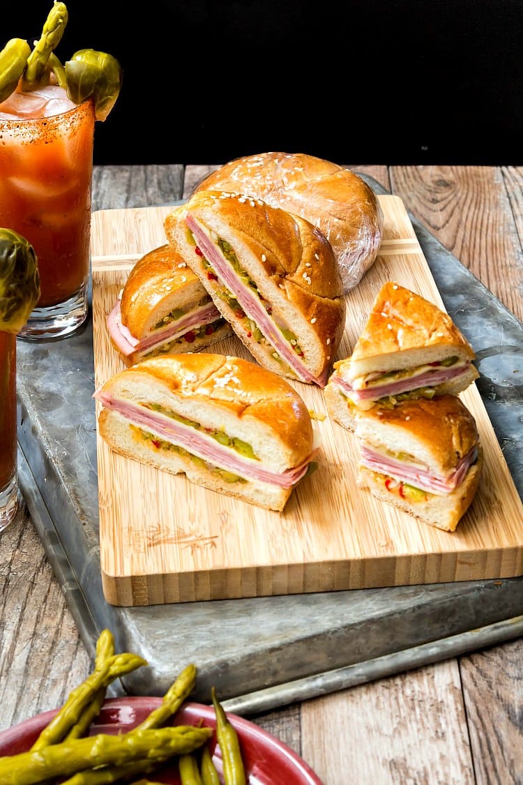 Several cut North Carolina Muffuletta sandwiches on a wooden board for serving.