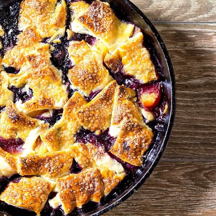 Overhead partial shot of a cast iron skillet of baked fruit pandowdy.