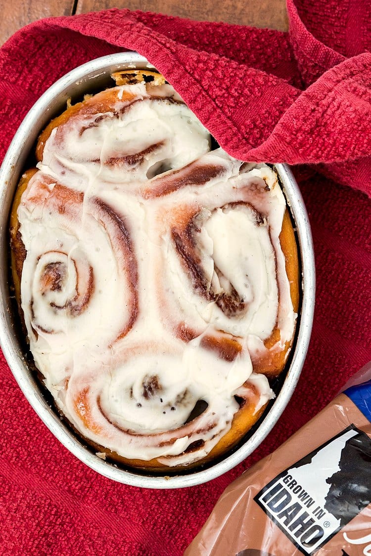 Overhead shot of an oval pan of 4 iced sweet rolls.