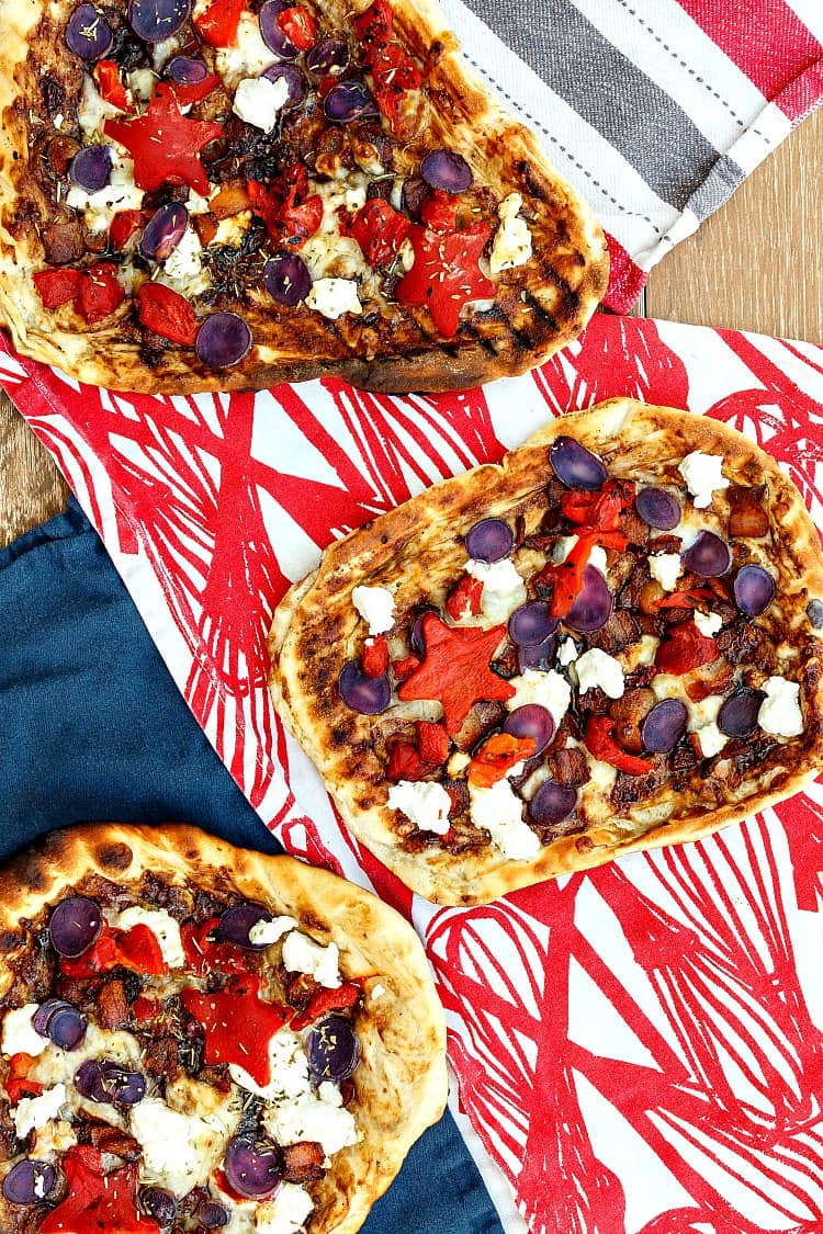You don't need food dyes to make this grilled patriotic pizza. A base of fig, onion, and balsamic jam, some crisp bacon and grated mozzarella all topped with patriotic colors: sweet roasted red peppers (cut into stars, if you like), blanched blue potatoes, and creamy, white goat cheese. It's a fantastic combination, and perfect for your 4th of July cookout! | pastrychefonline.com