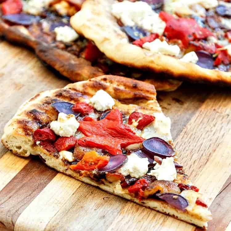 One slice of grilled pizza on a wooden table.