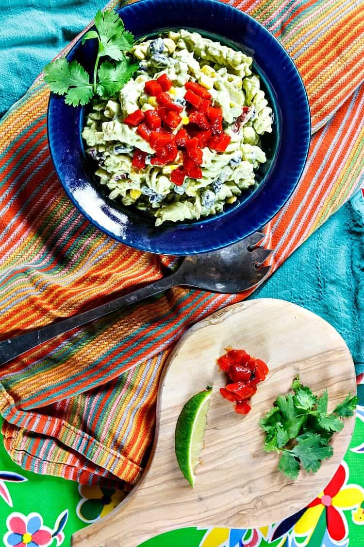 Overhead shot of Mexican green goddess dressing on pasta salad with lime and cilantro.