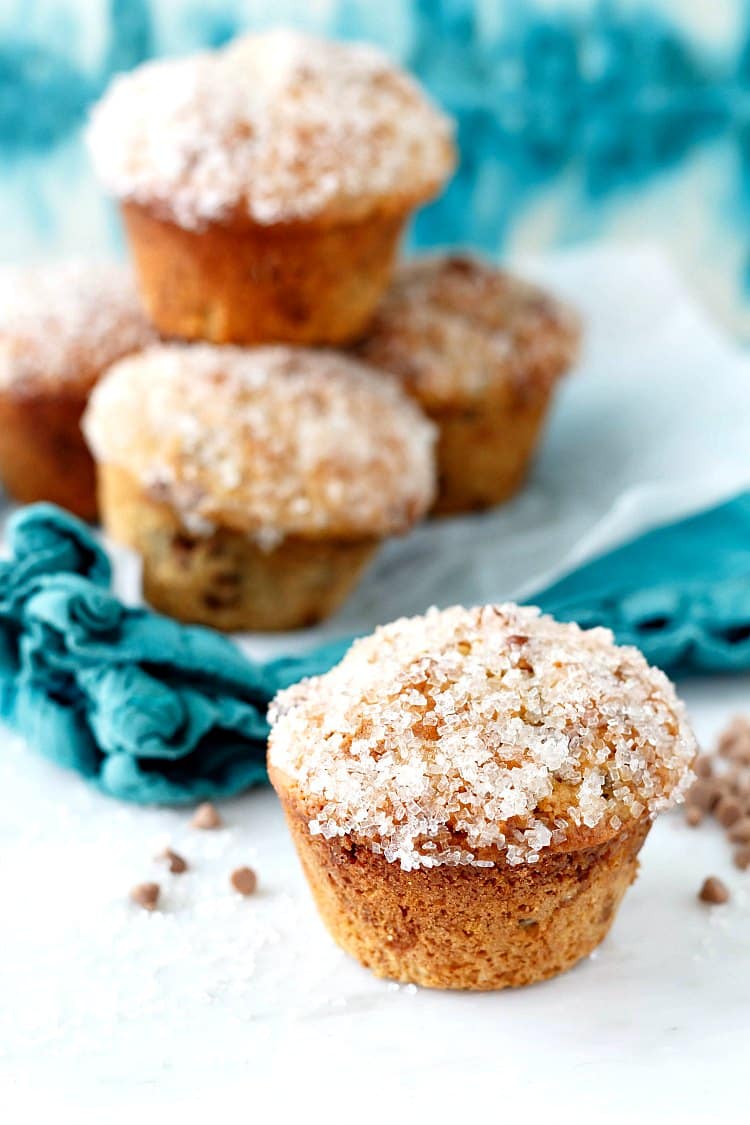 A stack of cinnamon raisin muffins with sparkly sugar on their tops.